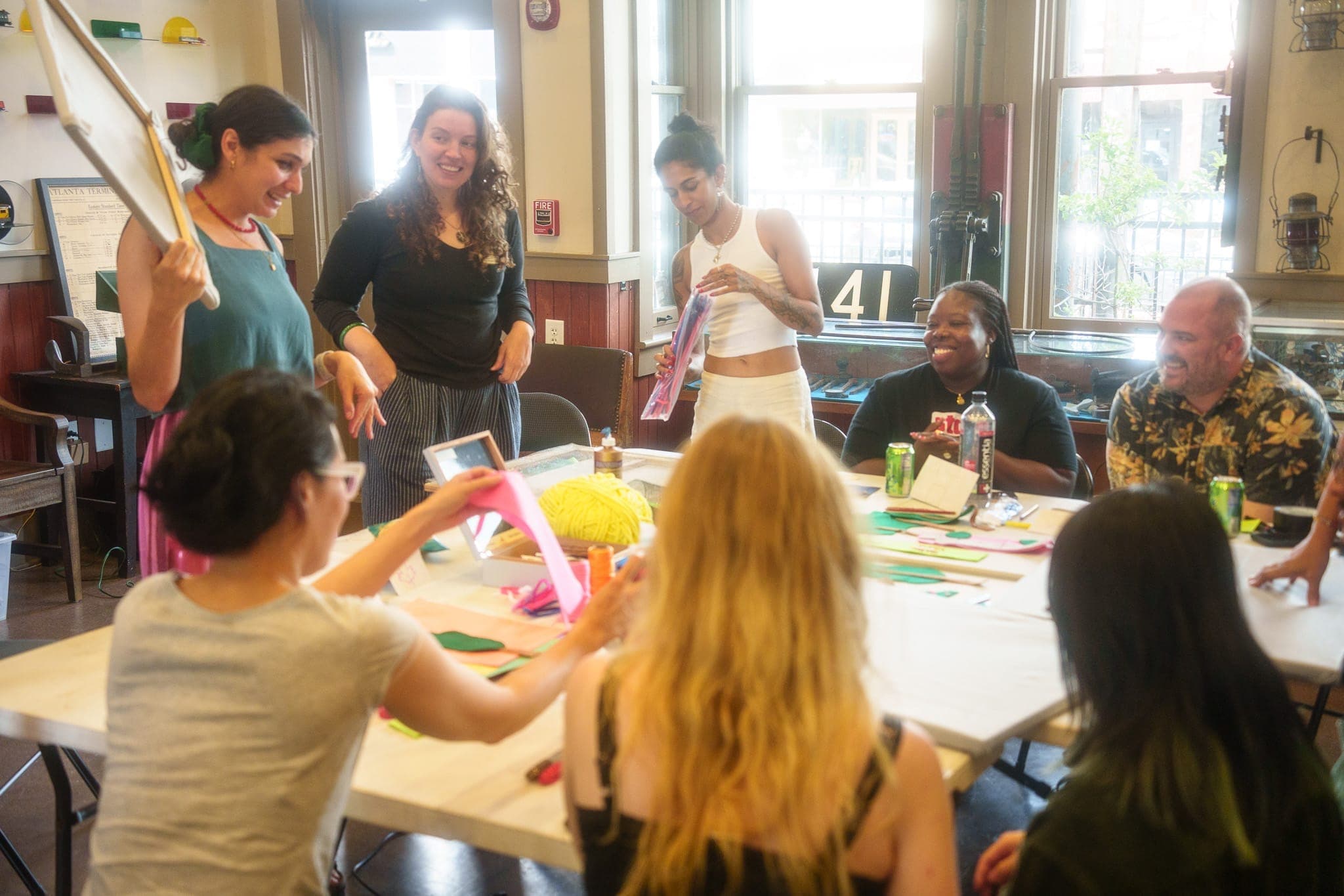 Atlanta_Hapeville Depot Museum_Jordan Young_03 People of all ages and backgrounds gather around a table set with different types of art supplies.