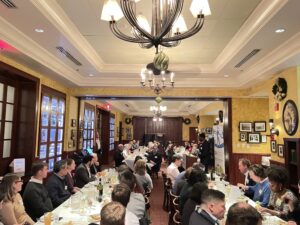 A dining room filled with people seated at long tables below a chandelier at the 11th annual Complete Streets Dinner.