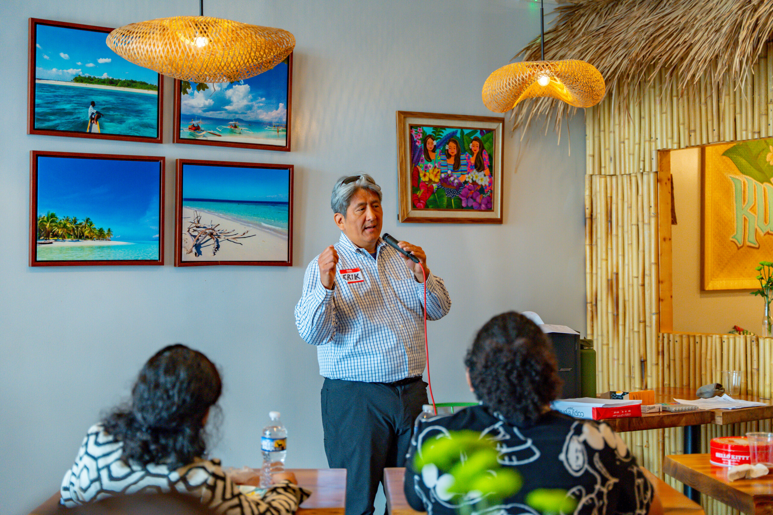 An Asian American man standing and speaking