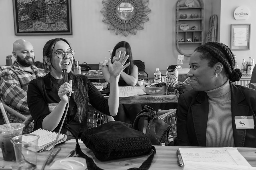 Two individuals smiling and enthusiastically engaging in conversation.