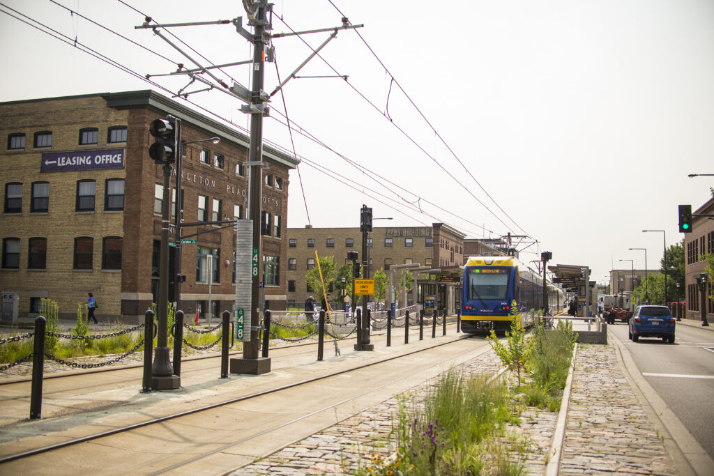 Train tracks and a train run through the center of housing development on both sides. 
